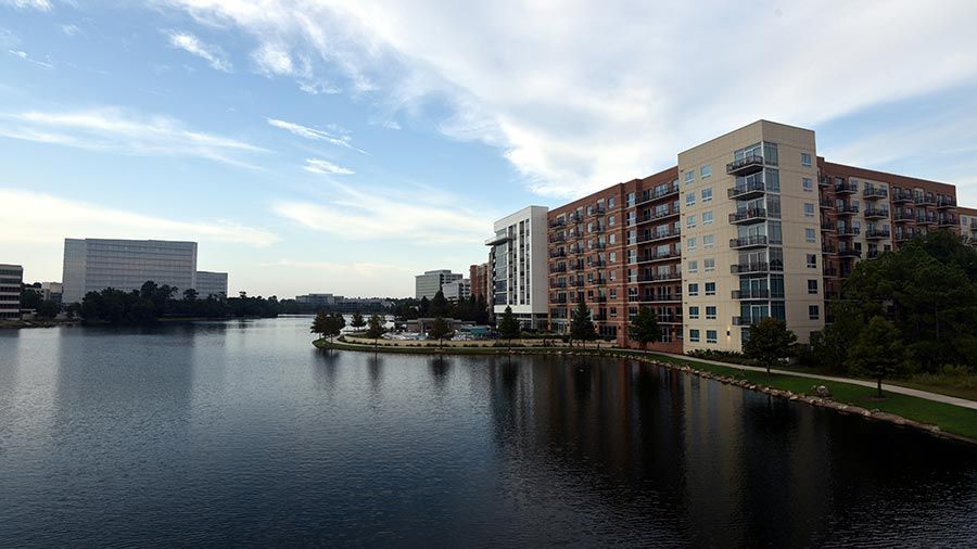 Waterfront view with modern apartment buildings and landscaped shoreline