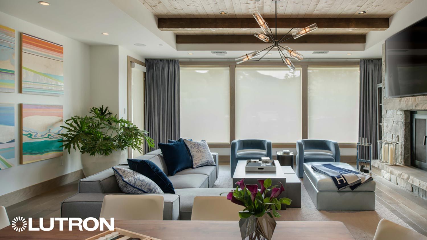Bright living room with motorized shades, exposed beams, and layered modern decor