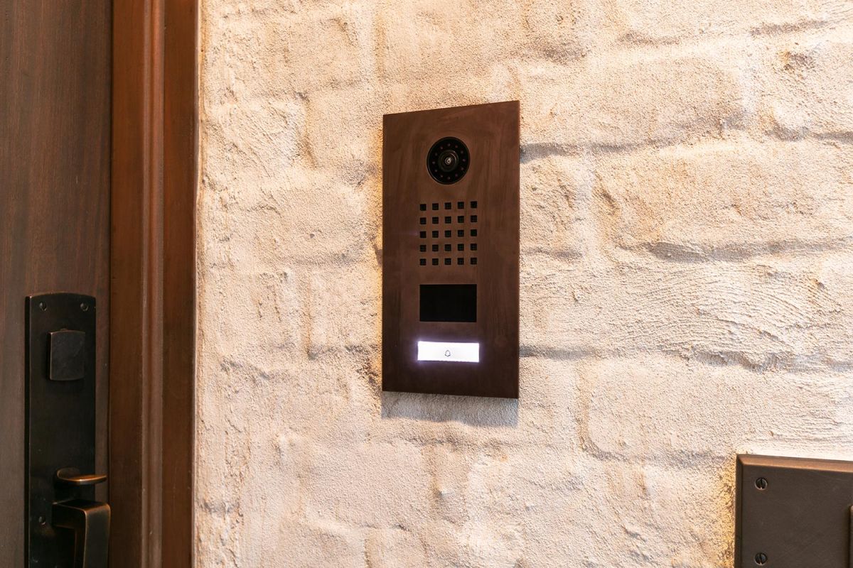 Wall-mounted security intercom on a textured brick surface