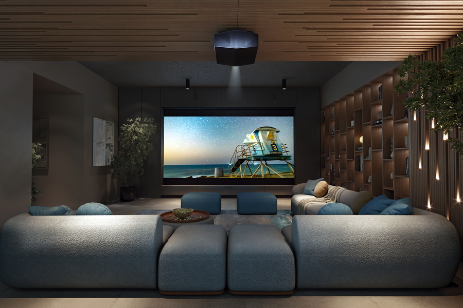 Luxury home theater room with plush blue seating, a large projection screen displaying a beach scene, wood-accented walls and ceiling, and soft ambient lighting.