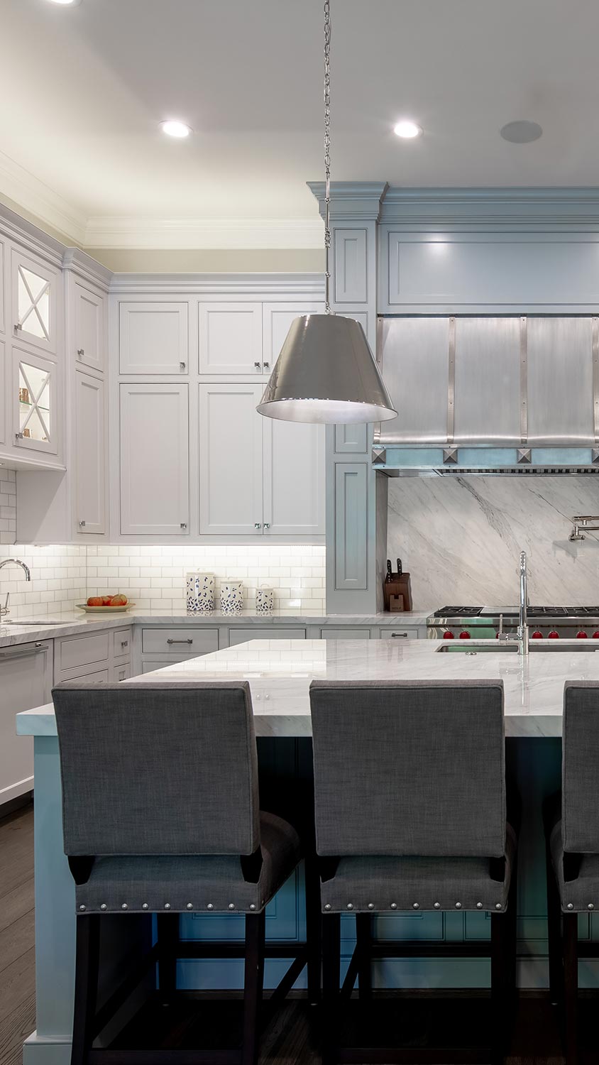 Bright kitchen with gray cabinets, stainless steel fixtures, and a large island with barstools