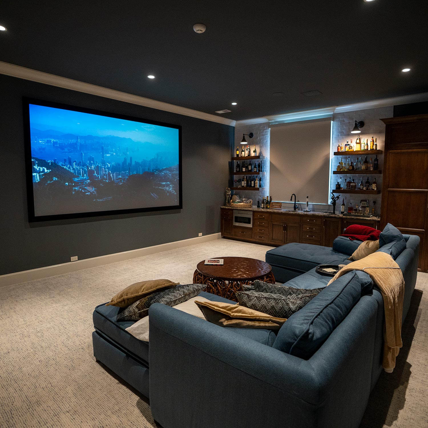 Cozy home theater with a large screen and blue sectional sofa