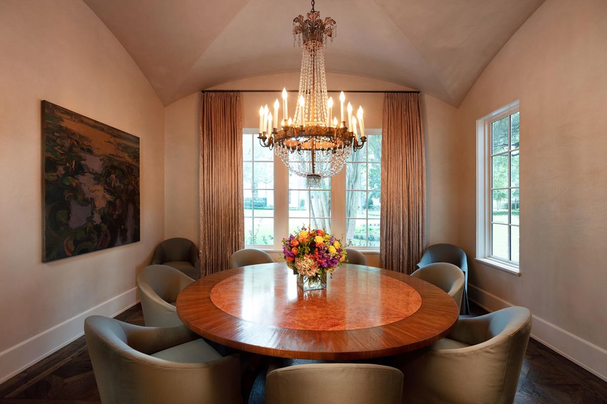 Intimate dining room with round wood table and crystal chandelier