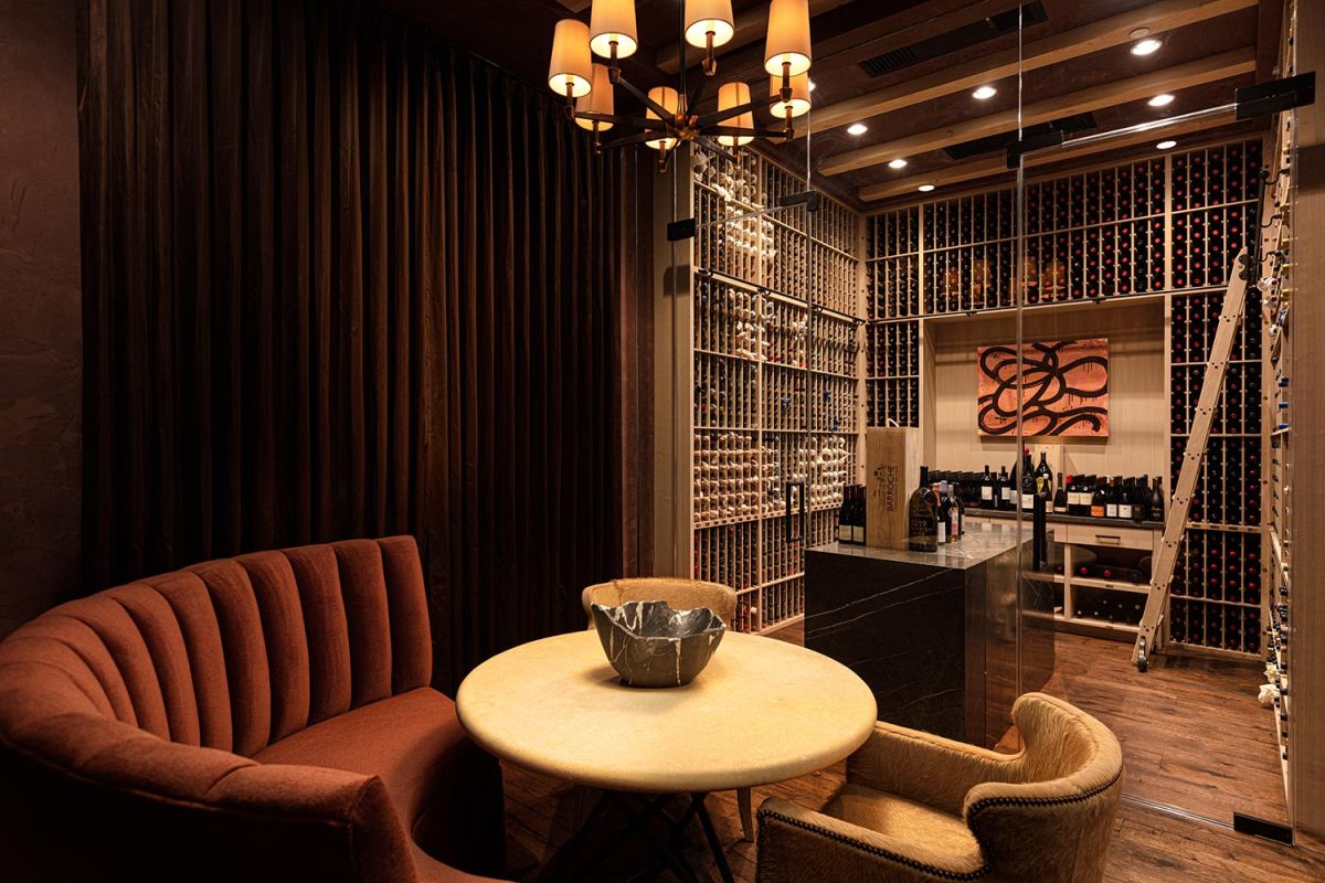Luxurious wine cellar with tasting table, chandelier, and bottle racks