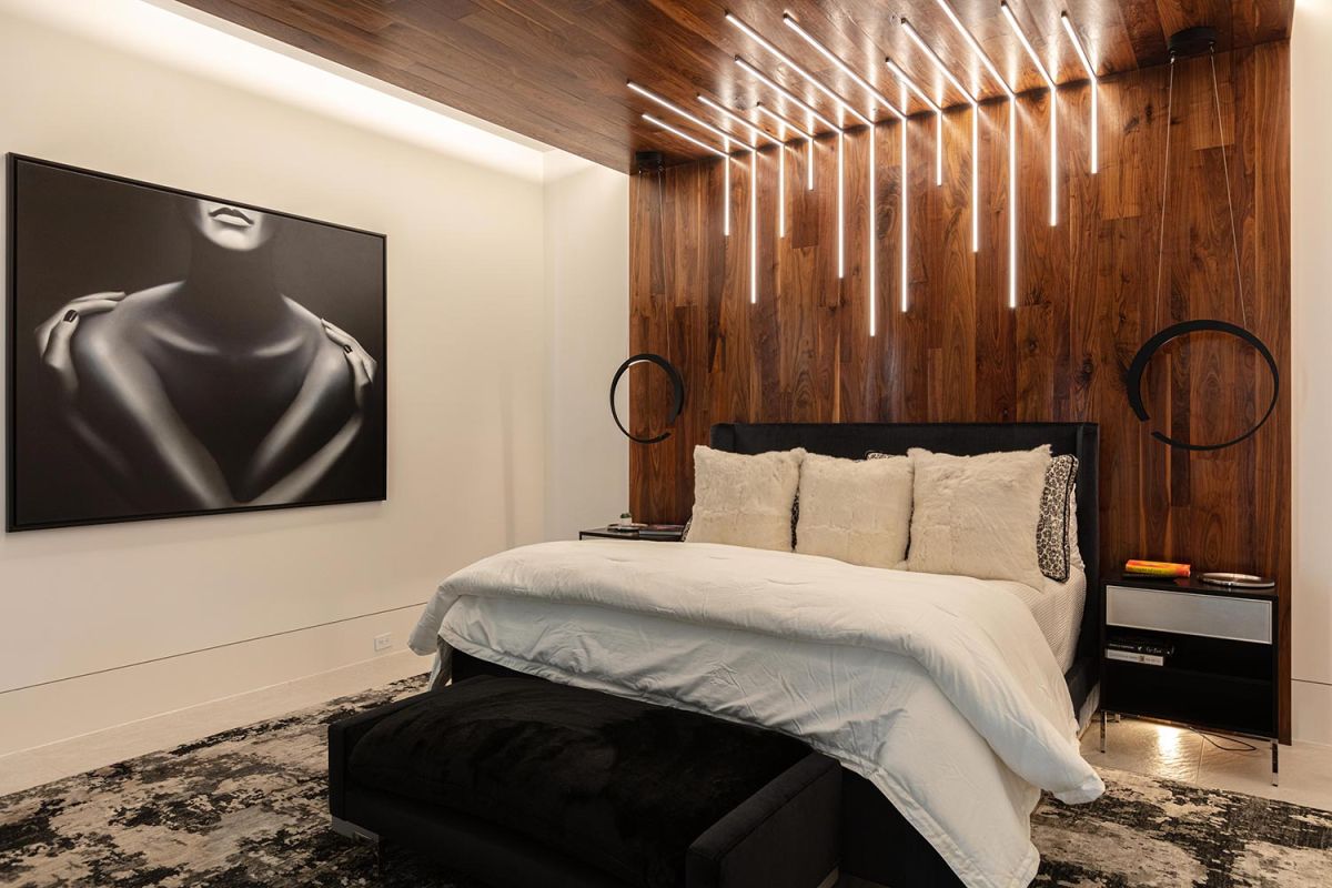Modern bedroom with wood panel wall and unique pendant lighting