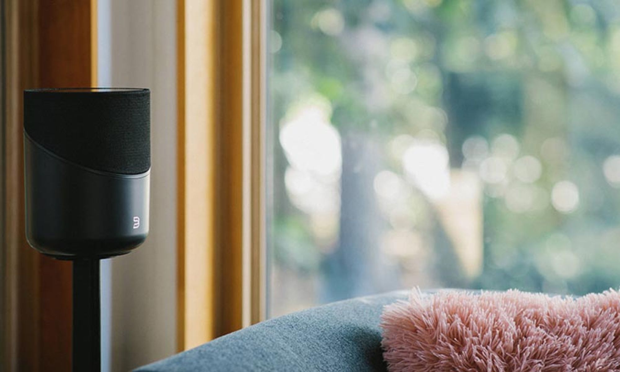 Black wireless speaker near a window