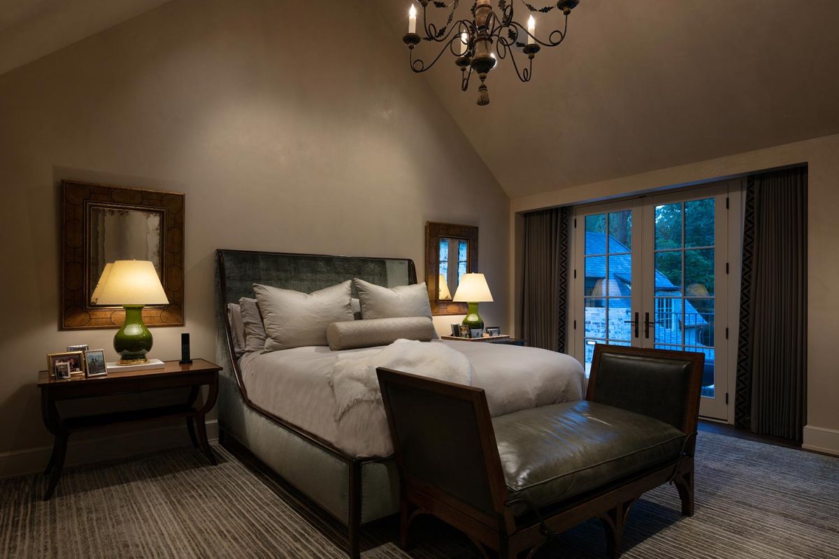Cozy bedroom with vaulted ceiling and double French doors to balcony