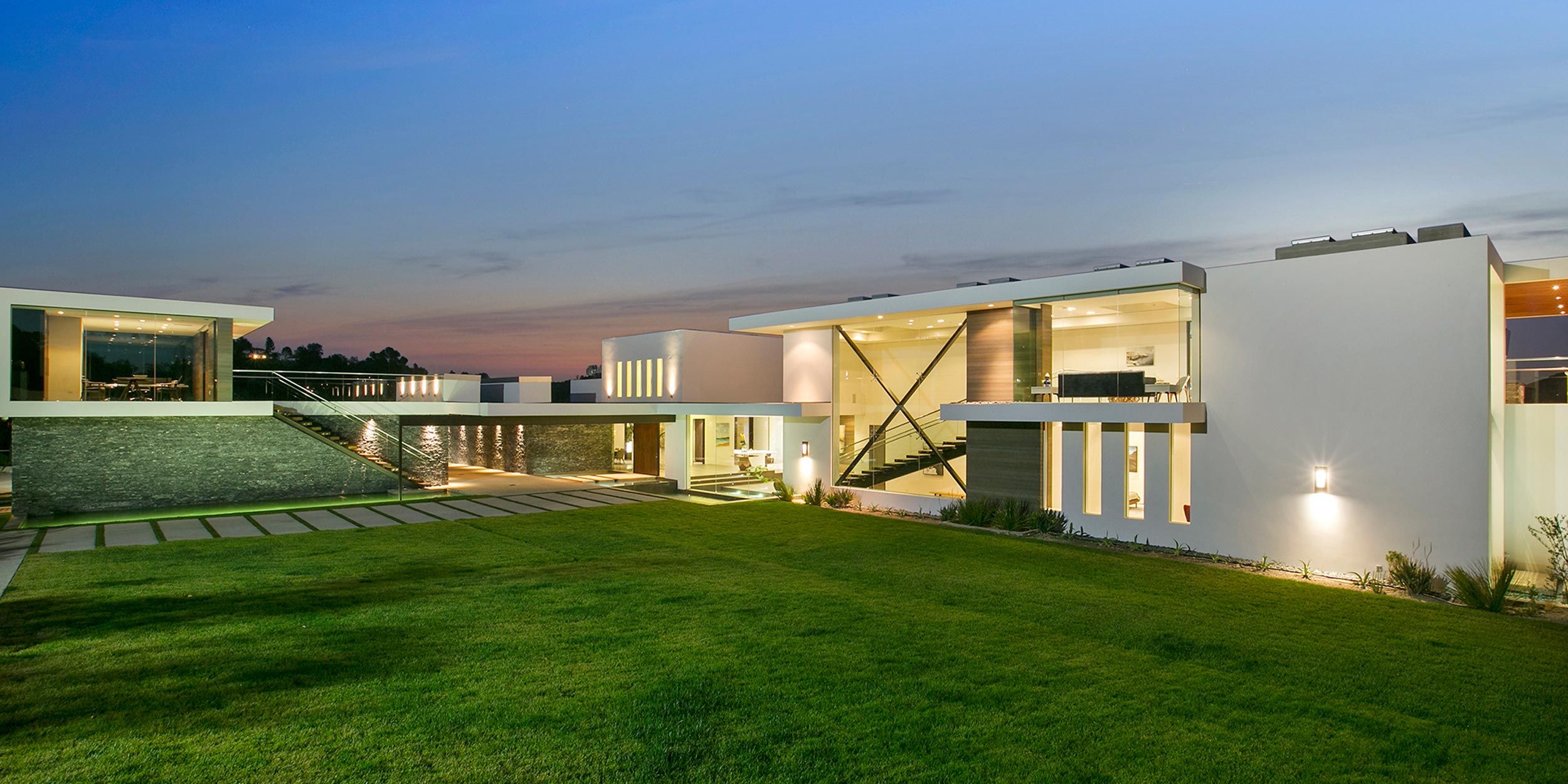 Elegant modern home with large glass windows and a landscaped yard