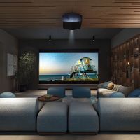 Luxury home theater room with plush blue seating, a large projection screen displaying a beach scene, wood-accented walls and ceiling, and soft ambient lighting.