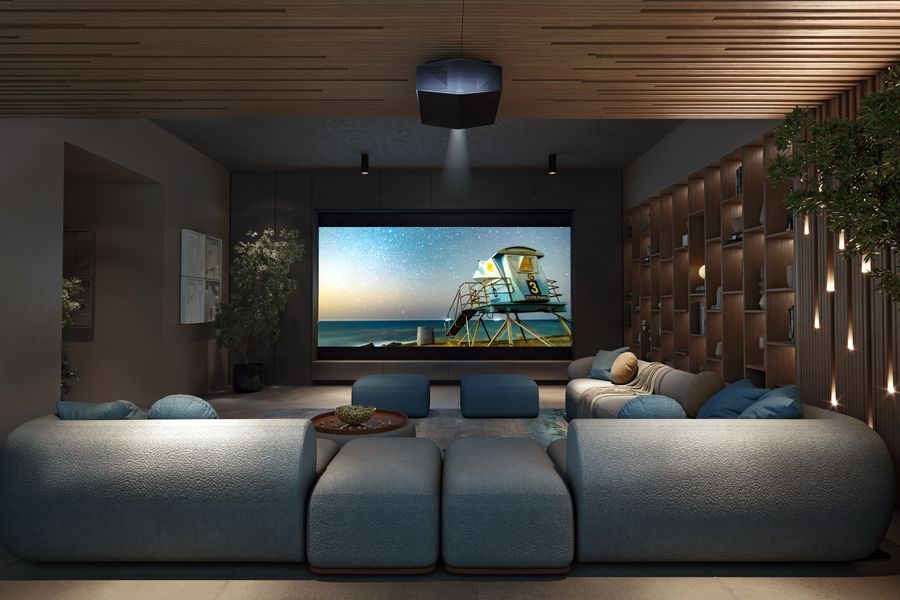 Luxury home theater room with plush blue seating, a large projection screen displaying a beach scene, wood-accented walls and ceiling, and soft ambient lighting.